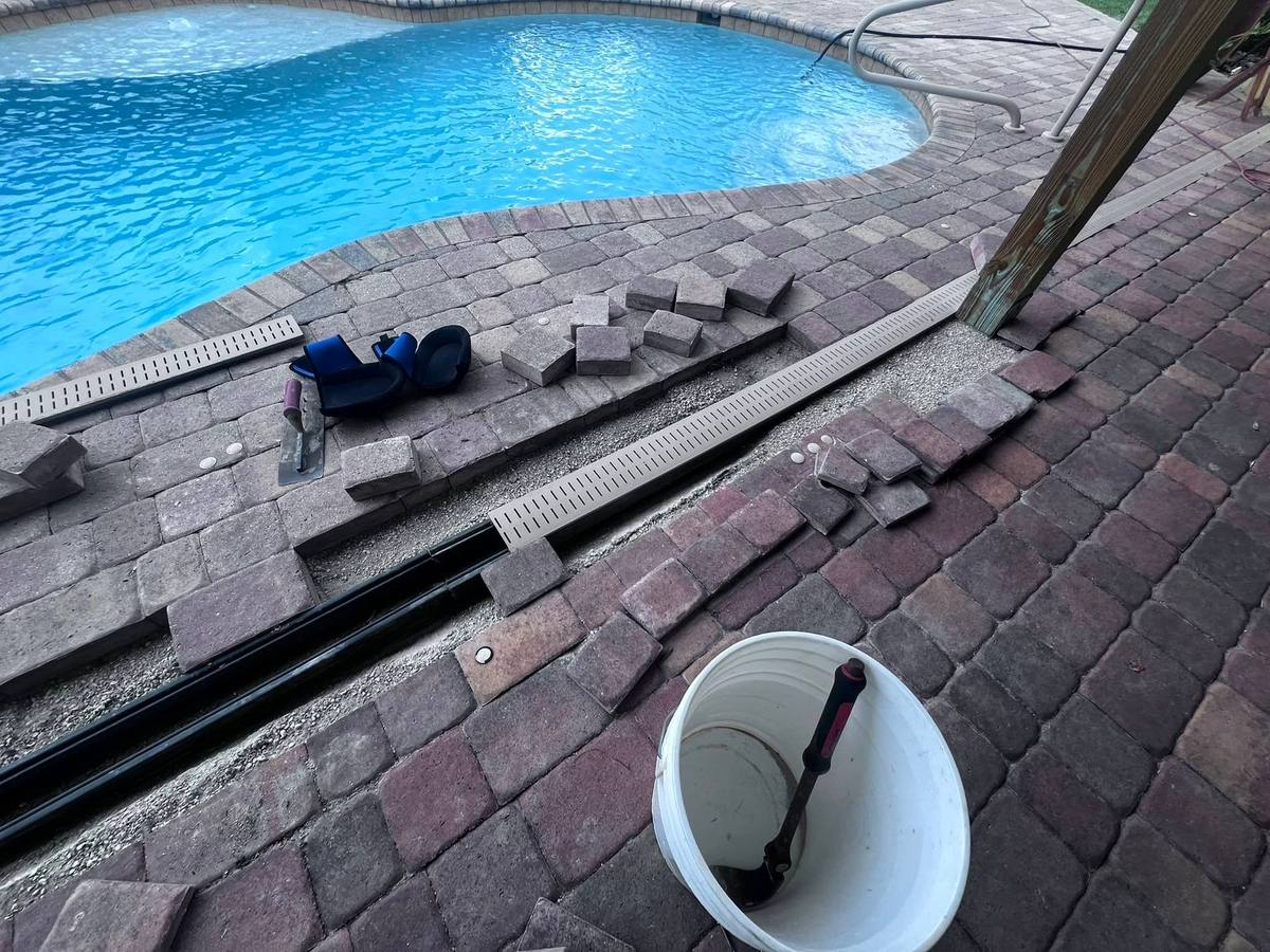 Deco drain trench drain being installed in a paver pool deck