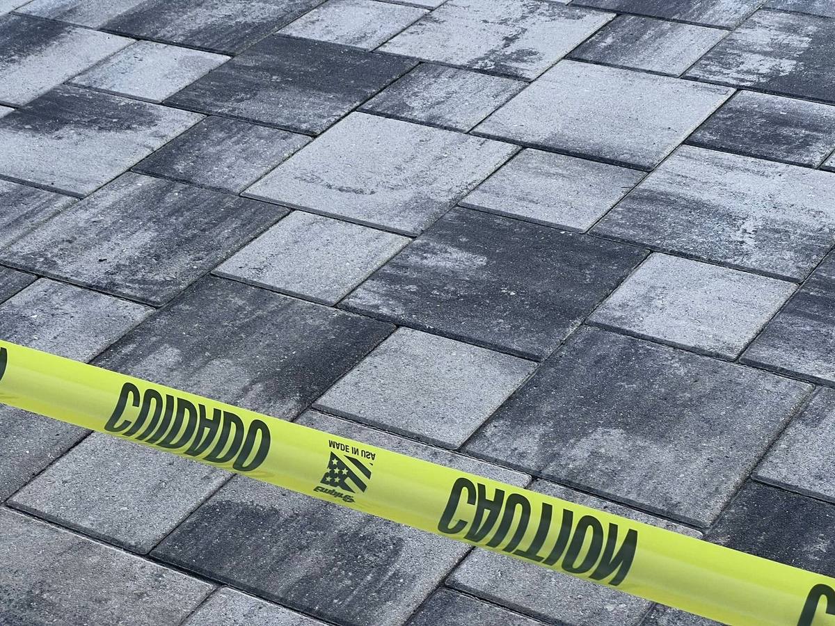 Fresh sealer curing behind the tape: paver cleaning & sealing by Paver Savers & Concrete