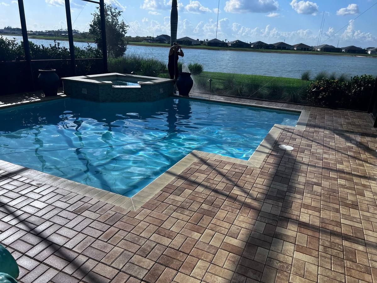 Cleaned and sealed paver pool deck and spa overlooking a lake at a Babcock Ranch home