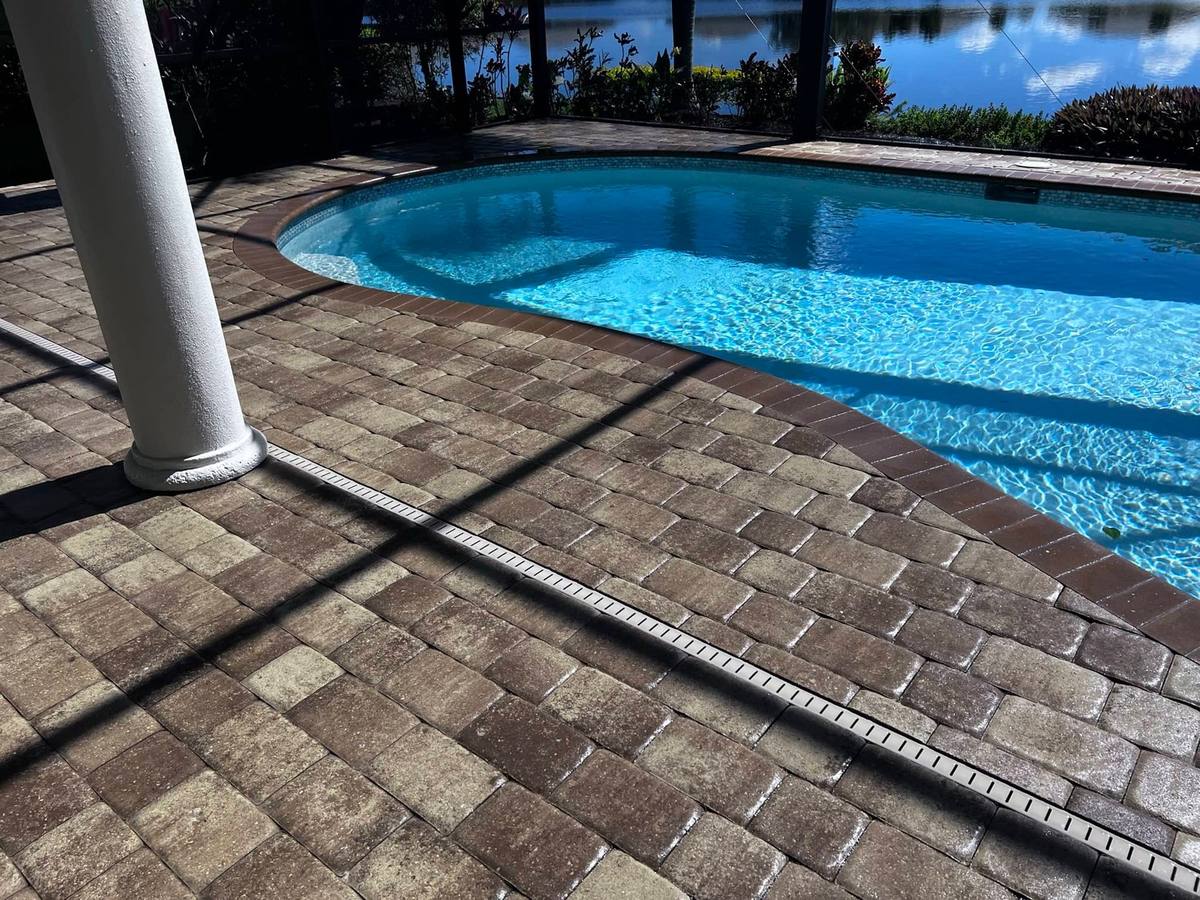 Trench drain along a sealed pool deck: drainage & deco drain by Paver Savers & Concrete