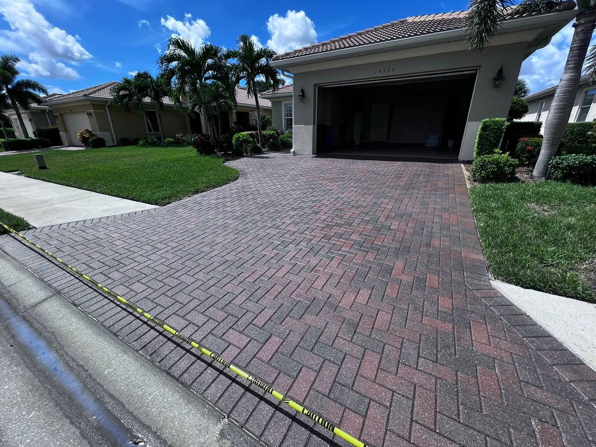 Freshly cleaned and sealed red herringbone paver driveway at a Pelican Preserve home in Fort Myers