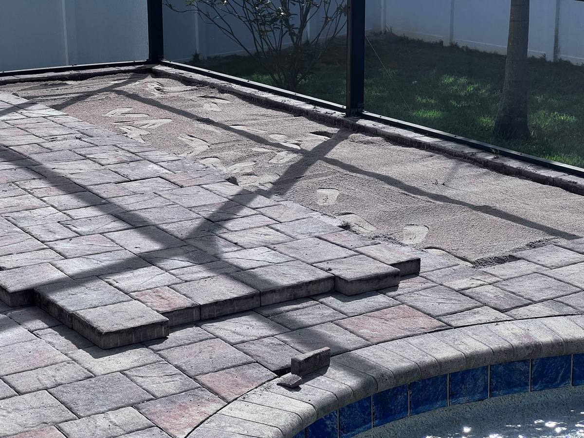 Sunken pool deck pavers lifted for re-leveling