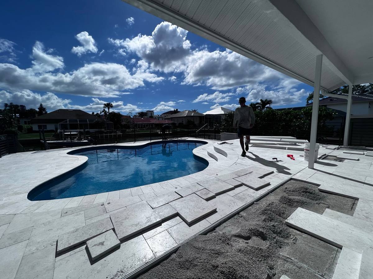 Travertine pool deck being repaired and reset at a Naples home